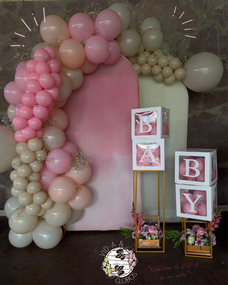 Mampara 180° para baby shower con fondos en tela rosa y crema, guirnalda orgánica de globos y cubos con letras BABY